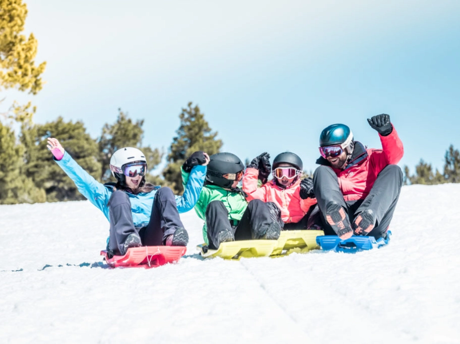 Familia disfrutando en trineo en la nieve